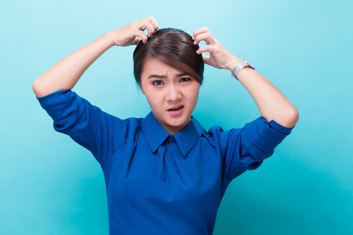 Seorang wanita sedang memegang rambut.