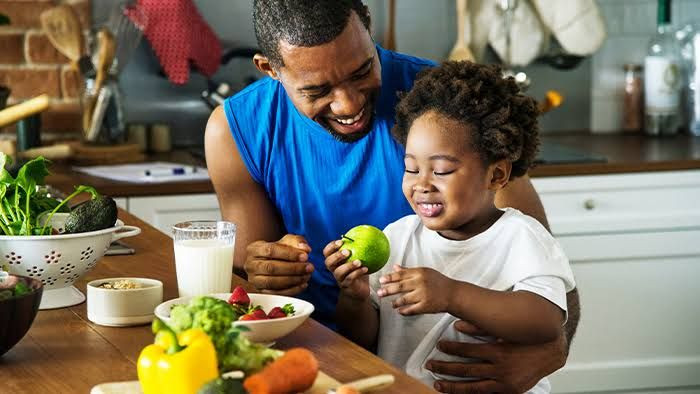 Ayah dengan anak makan makanan bergizi