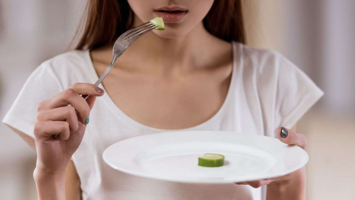 Seorang wanita makan dalam porsi sedikit