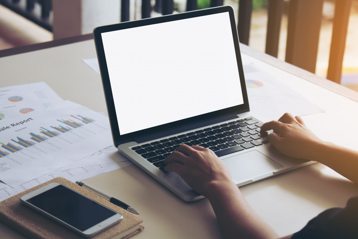 Seorang wanita sedang bekerja di depan laptop