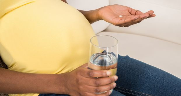 Wanita hamil sedang mengonsumsi obat.