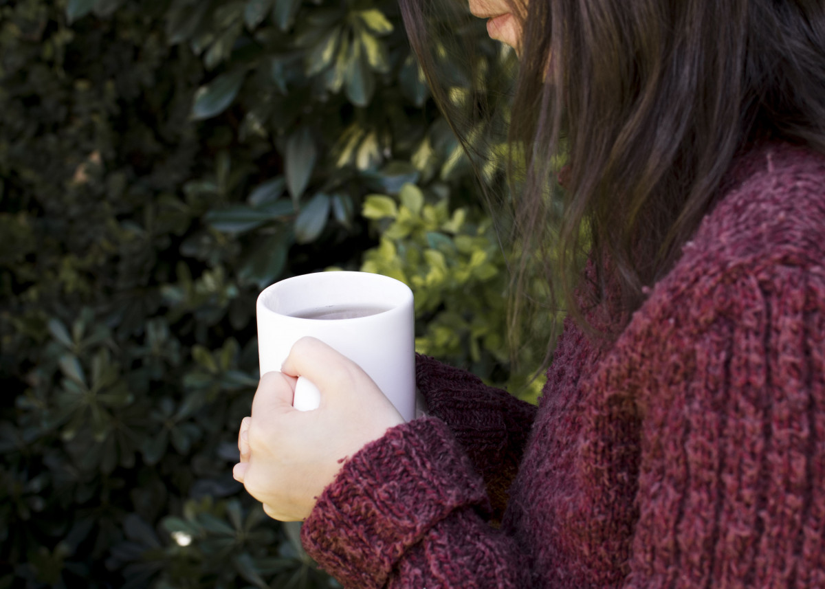 Seorang wanita sedang minum teh hangat.