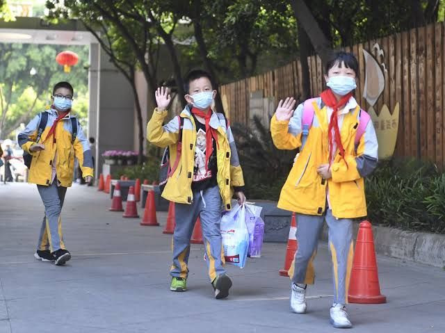 Anak anak yang bersekolah dengan menggunakan masker