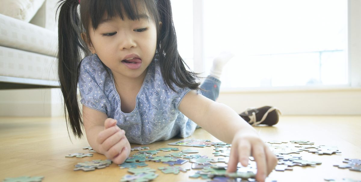 Seorang anak sedang bermain puzzle.