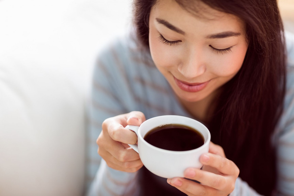 Wanita sedang minum kopi.