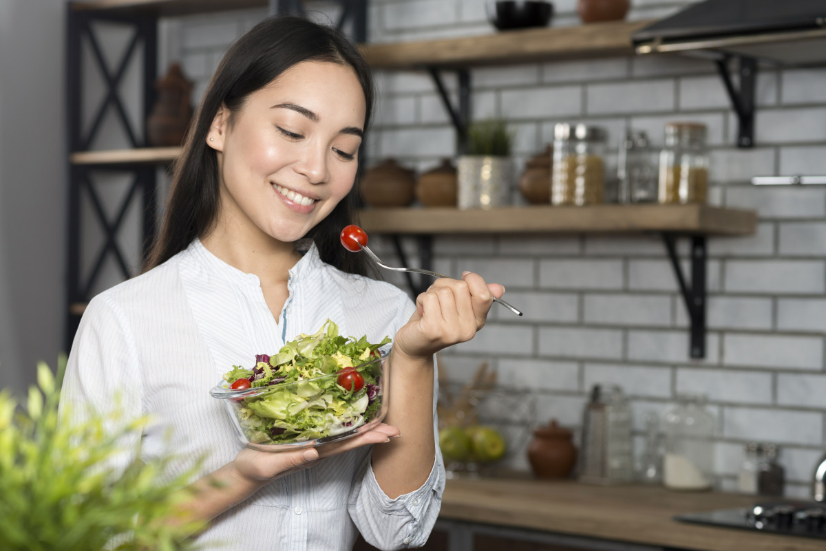 Seorang wanita makan salad.