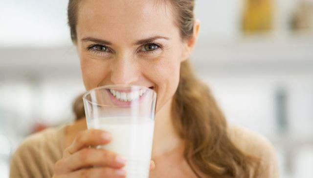 Seorang wanita sedang minum susu.