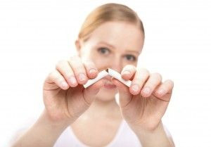 Remaja wanita mematahkan batang rokok.