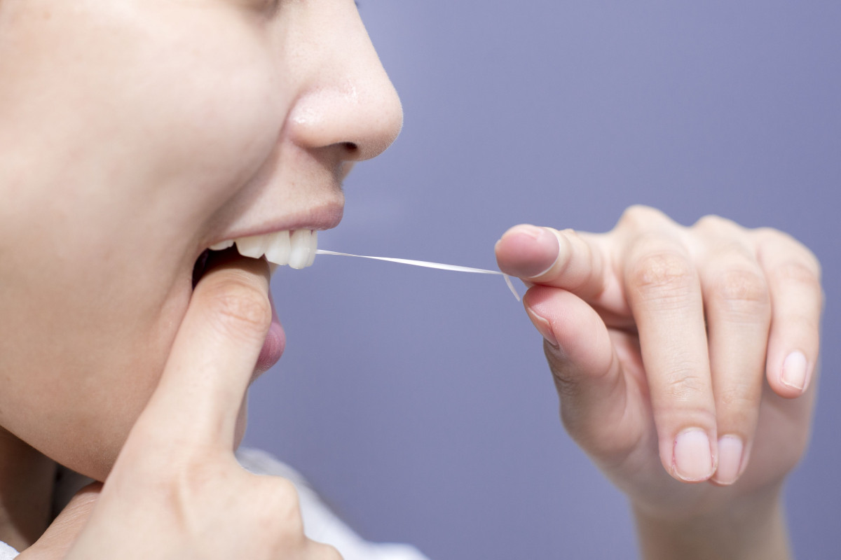 Seorang wanita sedang lakukan flossing.
