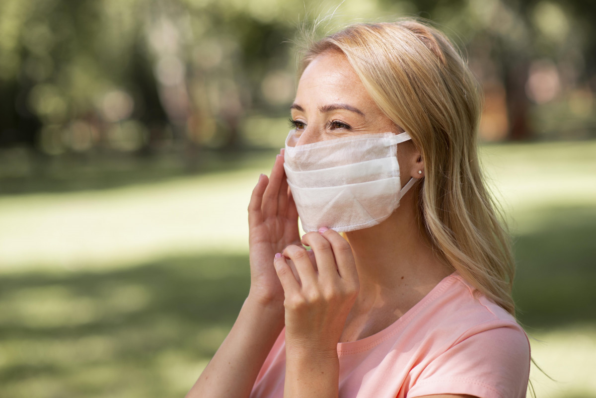 Seorang wanita sedang menggunakan masker.